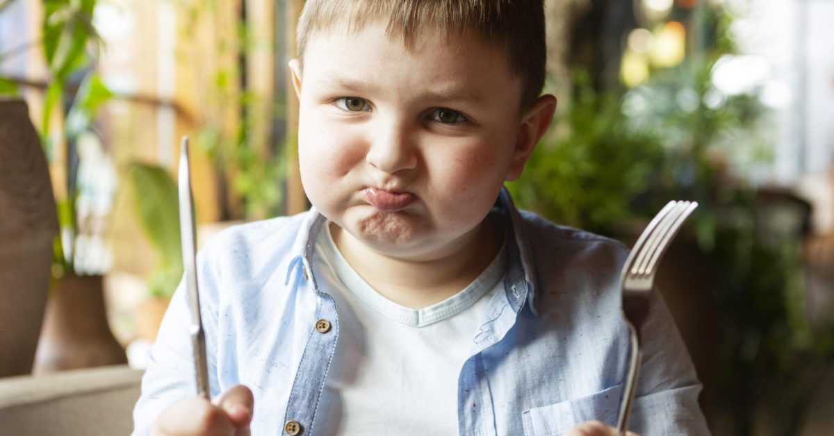 medium-shot-sad-kid-with-cutlery